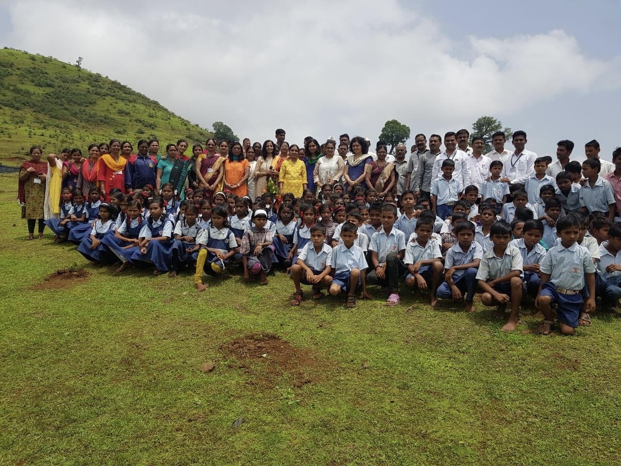 Students and community members gathered in a rural landscape